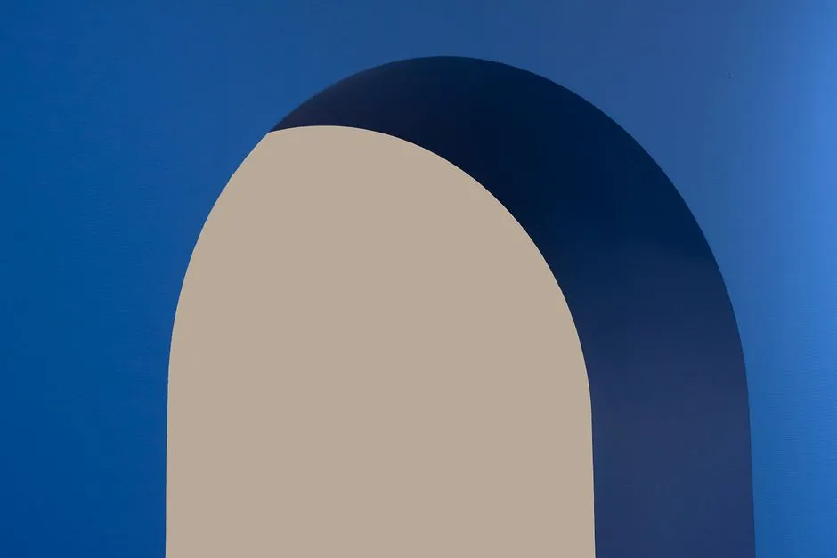 Minimalist abstract image featuring a blue arch against a beige background.