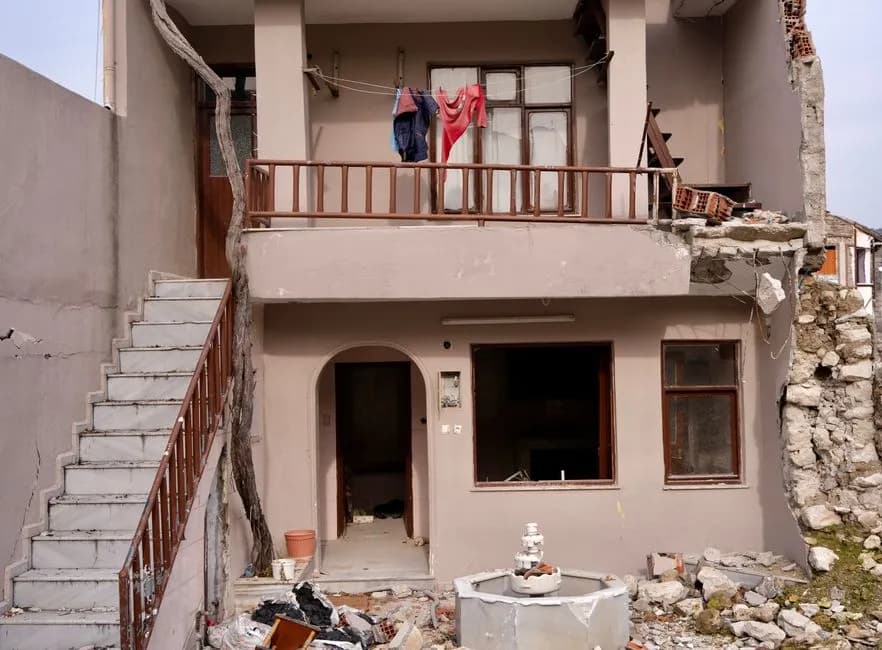Damaged residential building facade in Hatay, Türkiye, showing earthquake impact.