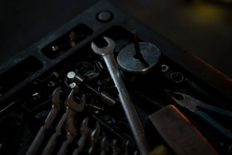A detailed view of assorted tools and wrenches in a dimly lit workshop environment.