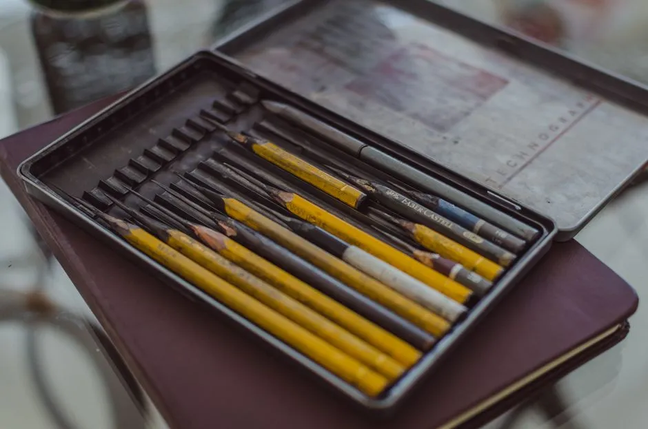 A neatly organized set of colorful art pencils inside a metal case, perfect for artists.