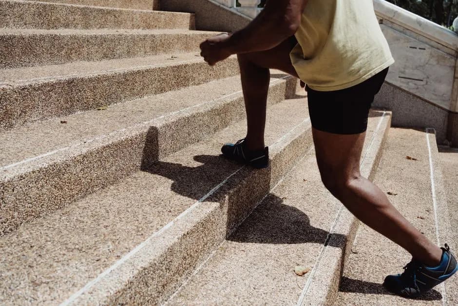 A man running up stone stairs outdoors, showcasing fitness and urban exercise.