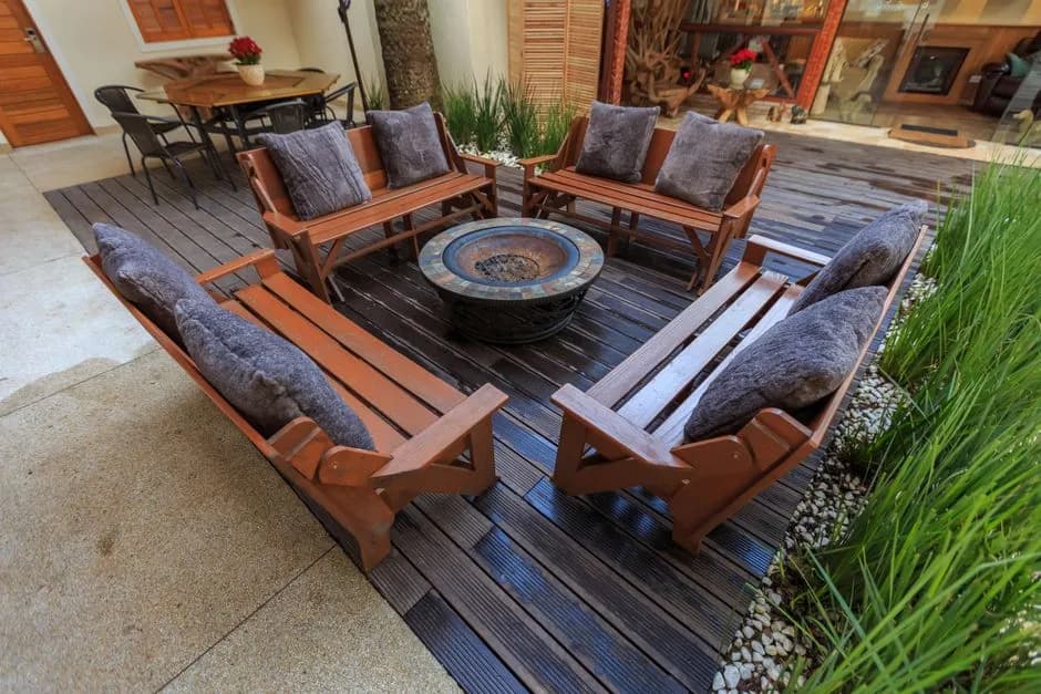 Inviting outdoor lounge with wooden benches and central fire pit, perfect for gatherings.