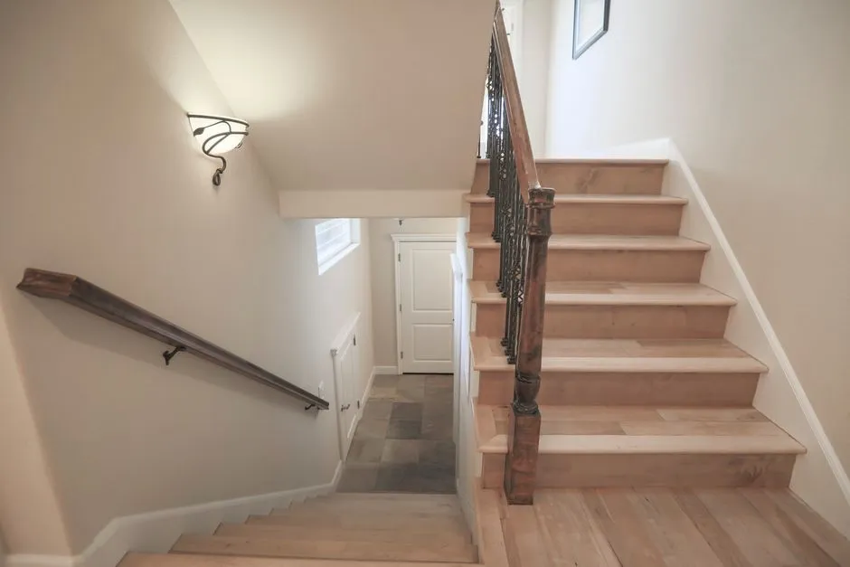 Luxurious wooden staircase with artistic railing in a modern home interior.