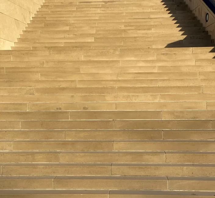 From below of wide empty stone stairway on city street on sunny day