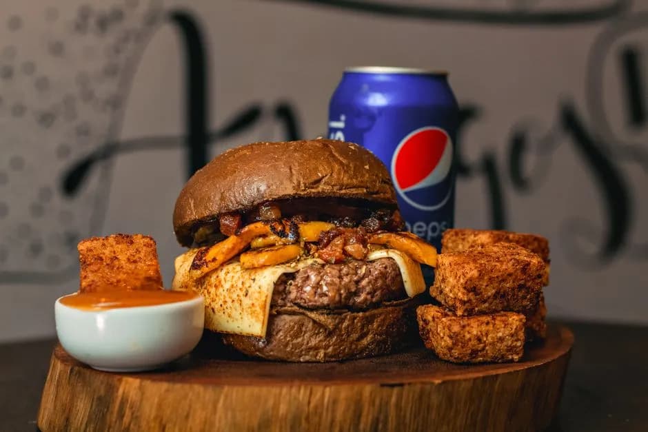 Delicious gourmet burger with fries and Pepsi can, perfect for a tasty lunch or dinner.