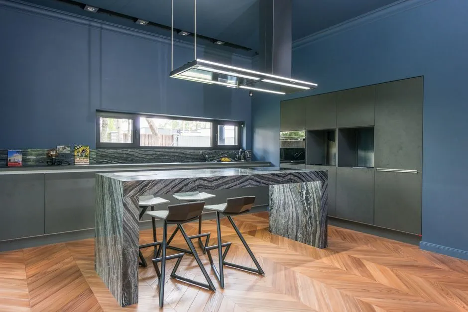 Contemporary blue kitchen featuring a sleek granite island and modern decor.