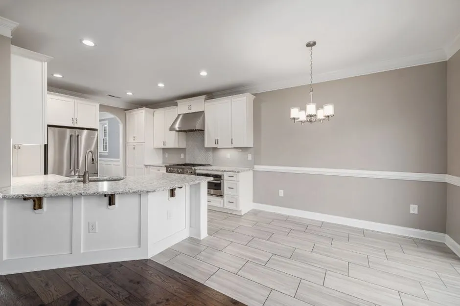 Bright modern kitchen with granite island and stainless steel appliances.