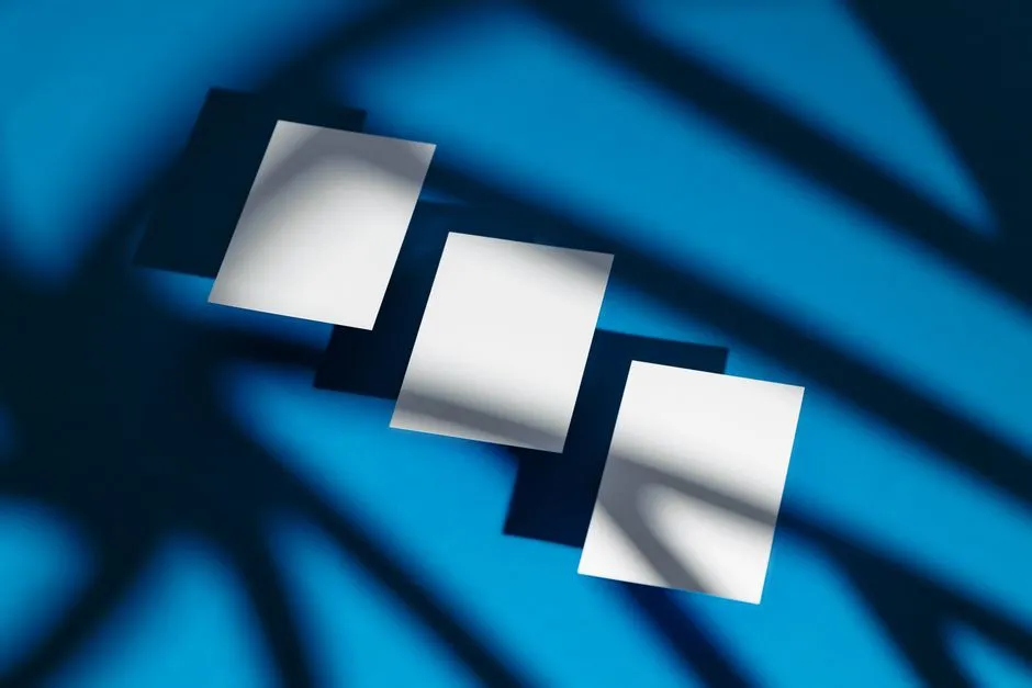 Modern abstract composition of white paper sheets casting shadows on a vivid blue background.