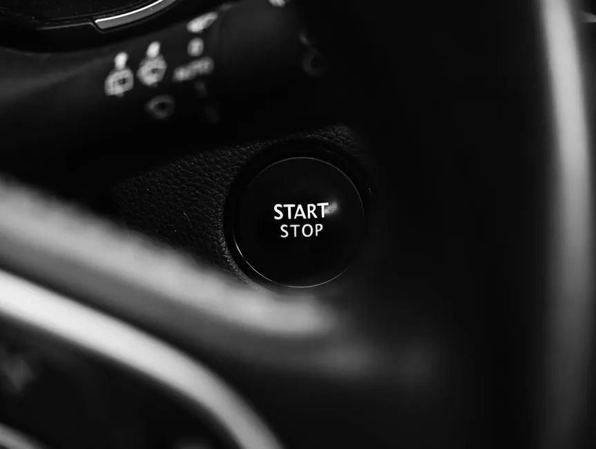 Detailed black and white image of a car's start stop button, perfect for automotive or technology concepts.
