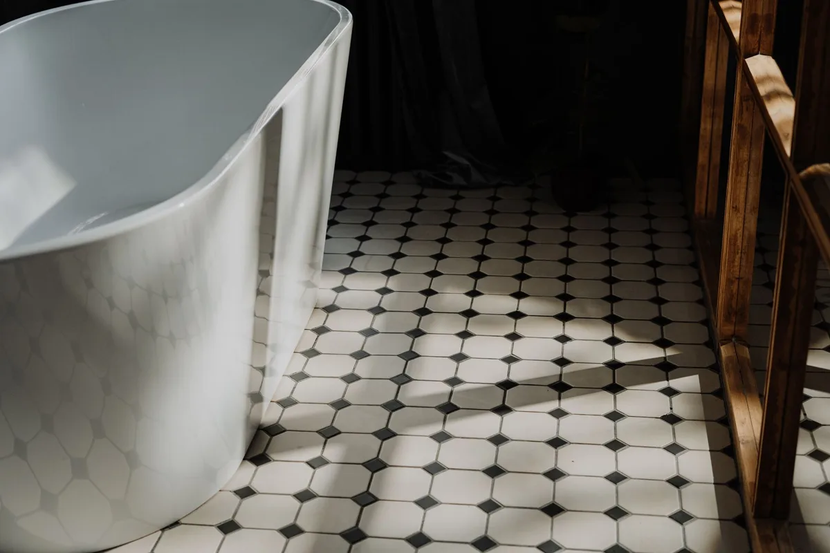 Minimalist bathroom with a freestanding tub and a floor of white hexagonal tiles
