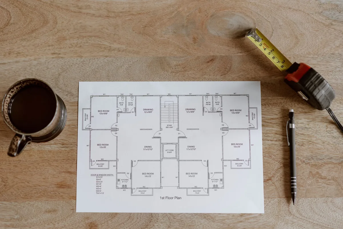 Measuring a room with a tape measure before drawing it in floor plan software