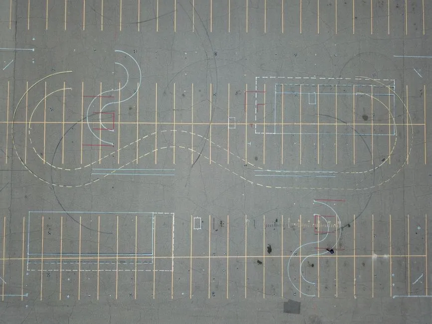 Aerial view of an empty parking lot featuring intricate road markings and parking lines.