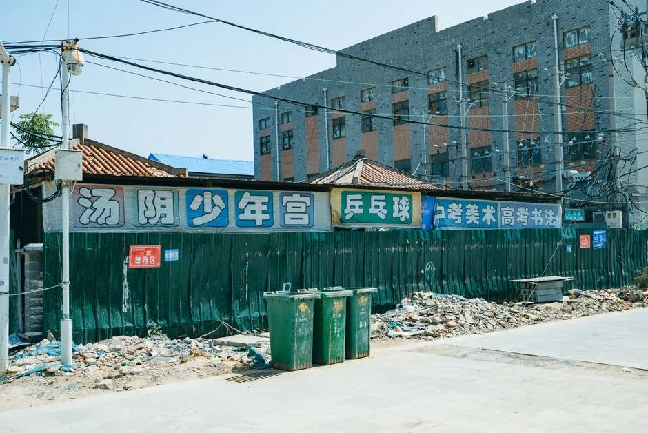 Urban construction site with Chinese signs and debris during the day.